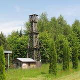 Drewniany szyb naftowy 
i zabudowania wokół niego w Muzeum Przemysłu Naftowego i Etnografii w Libuszy. W tle las.