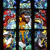 Wysokie okno z kolorowym witrażem przedstawiającym Chrystusa w koronie z cierni na głowie, ze złotym berłem w dłoni, a drugą dłoń trzyma przy twarzy jakby w zadumie.