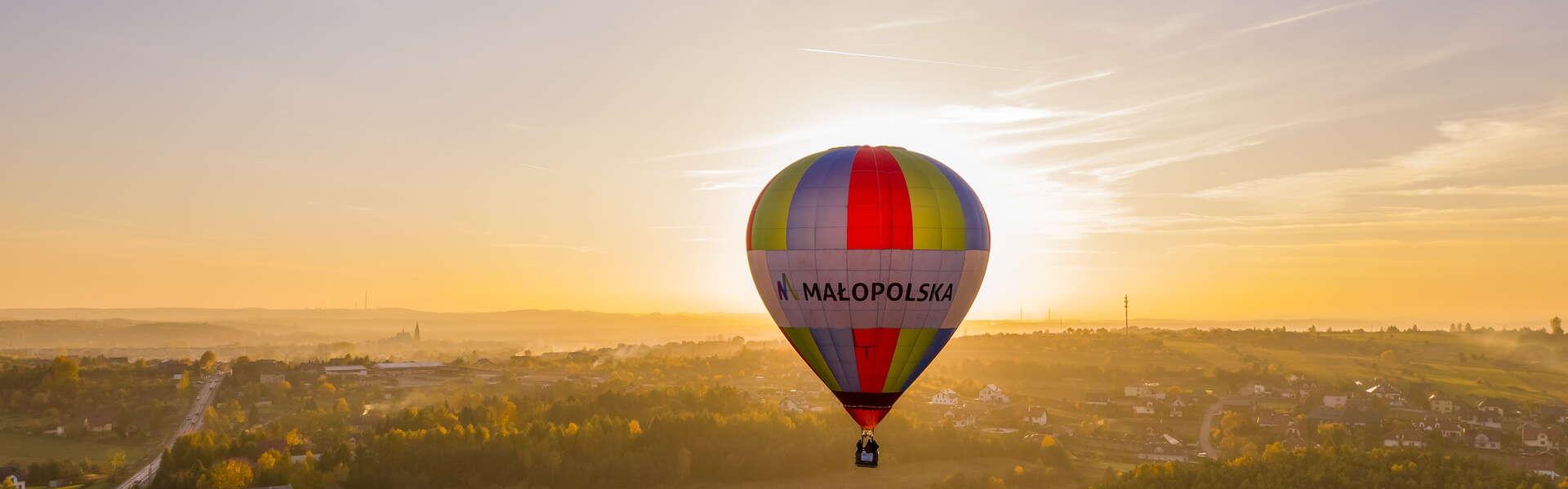 A balloon in the air with the peaks of the Three Crowns (Trzy Korony) and the Dunajec River in the background.