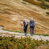 Dwie starsze osoby idą kamienistą ścieżką